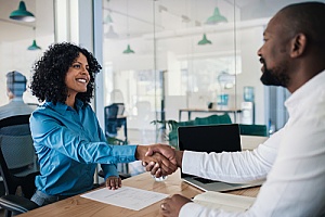 a small business owner shaking hands with a third-party HR consultant