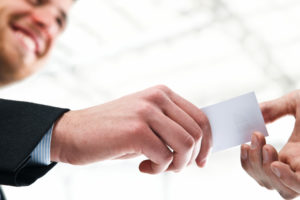 HR consultant hands business card to a prospective client