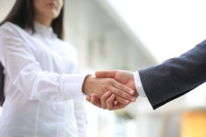 hr consultant shakes employee hand before they talk about the conflict in the workplace