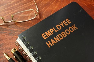 employee handbook on a wooden table and glasses