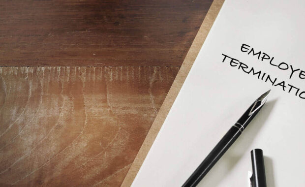 employee termination words written on notebook on working desk